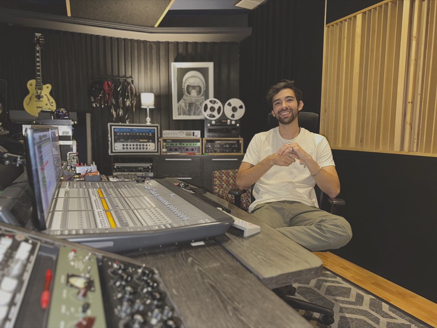 Alejandro Ramírez López sentado frente a una consola de mezcla en su estudio.